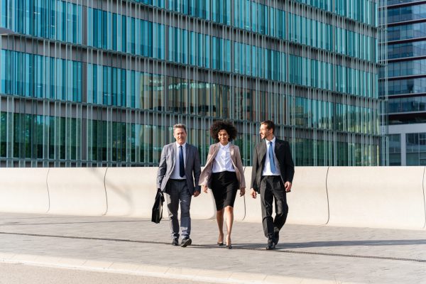 Multiracial group of business people bonding outdoors - International business corporate team wearing elegant suit meeting in a business park